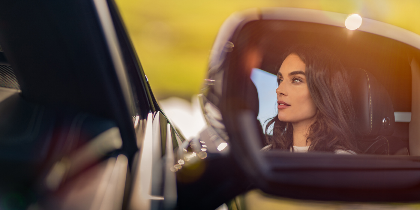 Bentley Hamburg profile of dark haired woman's face in mirror of Bentley car in sunlight