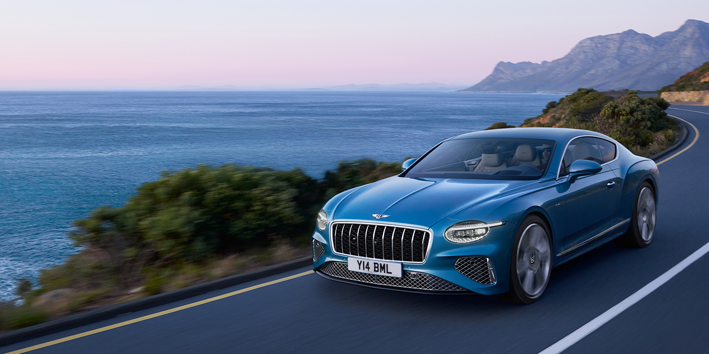 Bentley Hamburg New Bentley Continental GT Azure coupe in Light Windsor blue paint with 22 inch Azure wheels and chrome grill, driving dynamically by the sea