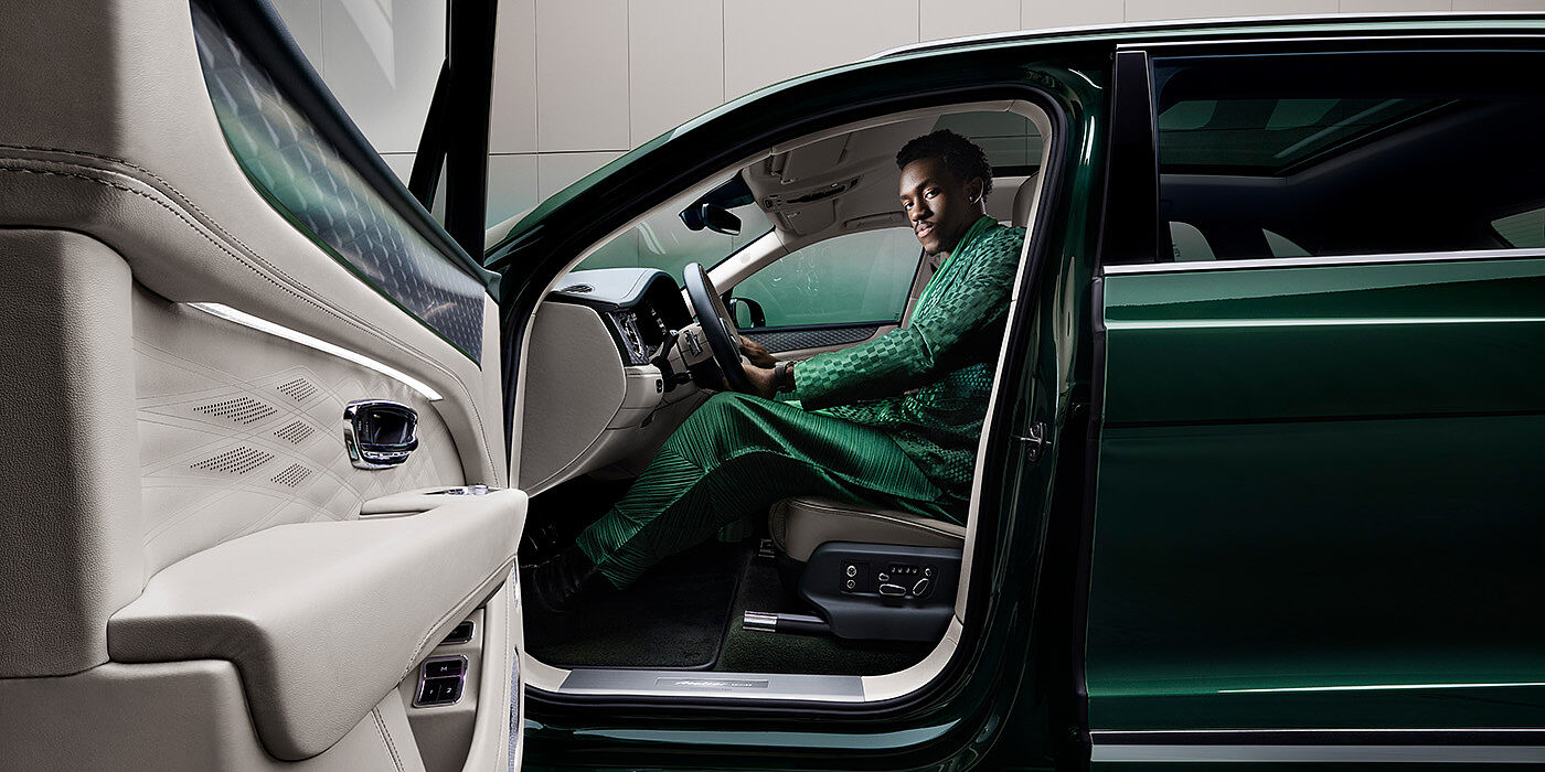 Bentley Hamburg Wisdom K seated in Bentley Bentayga Extended Wheelbase SUV in Light Emerald green paint with door open